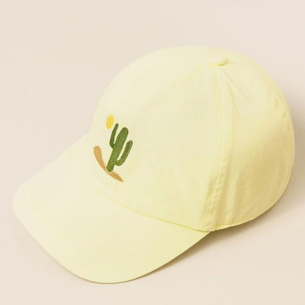 A pale yellow Cactus Embroidered Cotton Baseball Dad Cap featuring a cactus and sun design on the front with a relaxed fit and pre-curved visor.