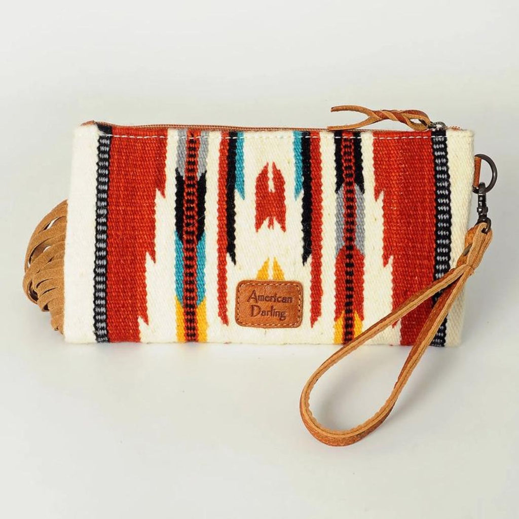 Back view of the Canyon Breeze Fringe Wristlet showcasing the vibrant woven red, yellow, and blue pattern with the American Darling leather patch.