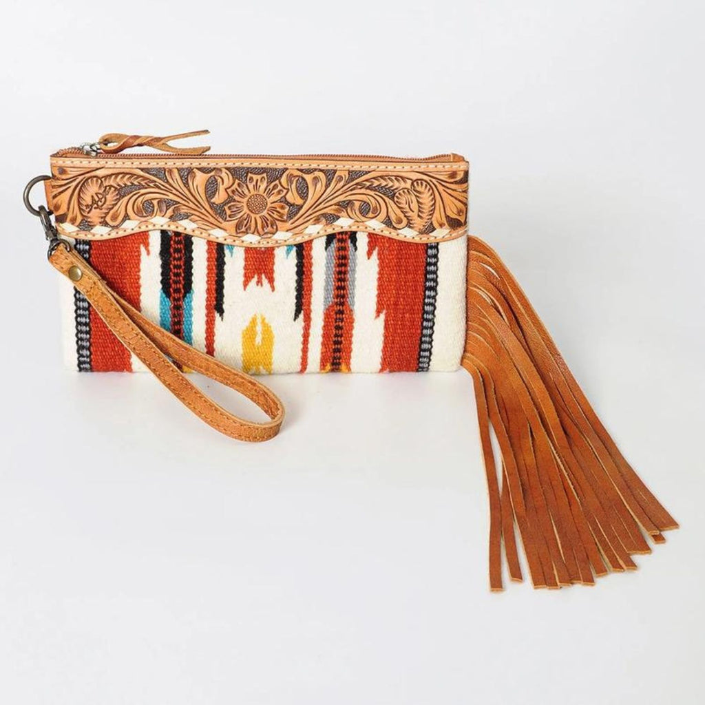 Front view of the Canyon Breeze Fringe Wristlet with hand-tooled leather floral design and vibrant woven pattern in red, yellow, and blue.