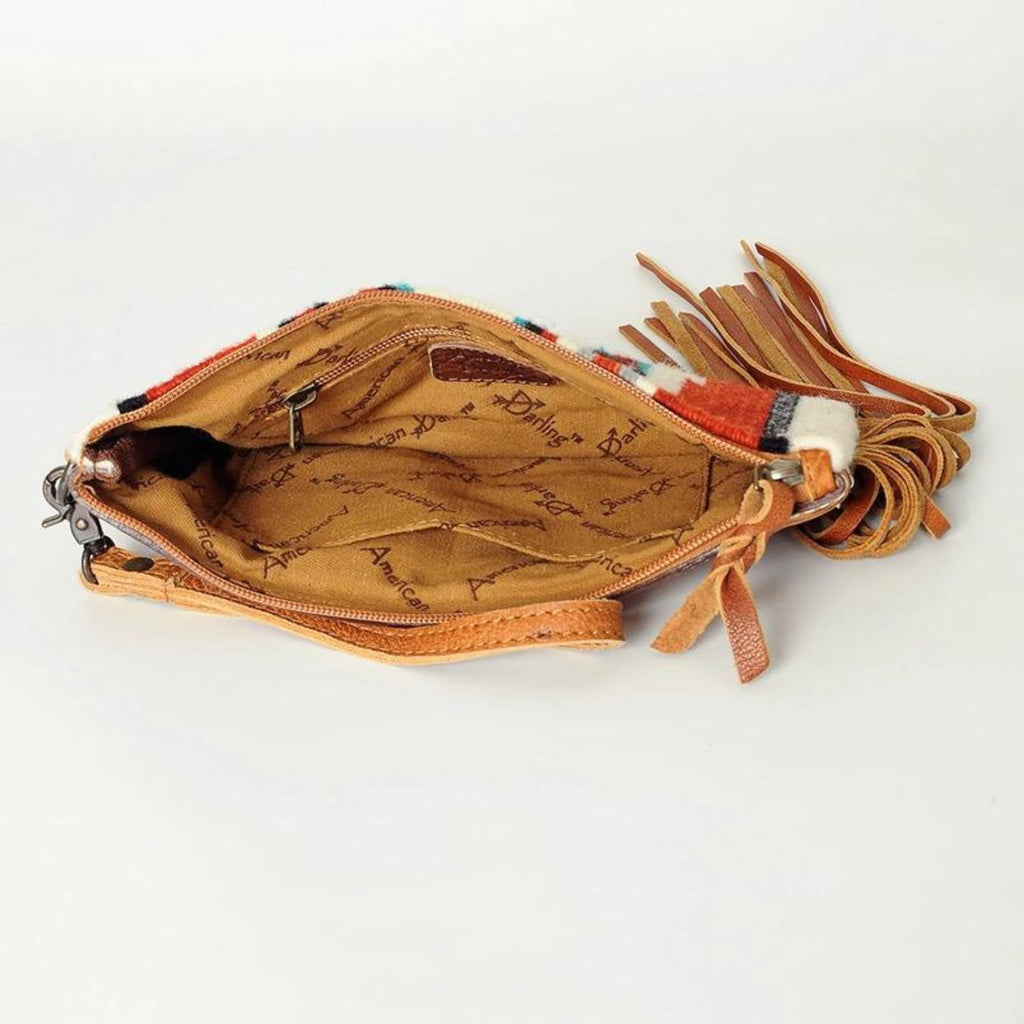 Interior view of the Canyon Breeze Fringe Wristlet showing the spacious interior with a tan lining and American Darling branding, alongside a secure zipper pocket.