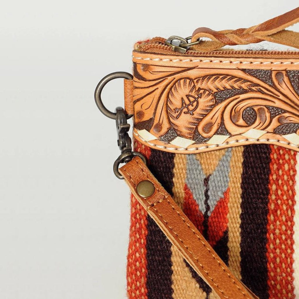 Close-up detail of the Desert Bloom Handcrafted Wristlet showing hand-tooled leather and metal hardware.