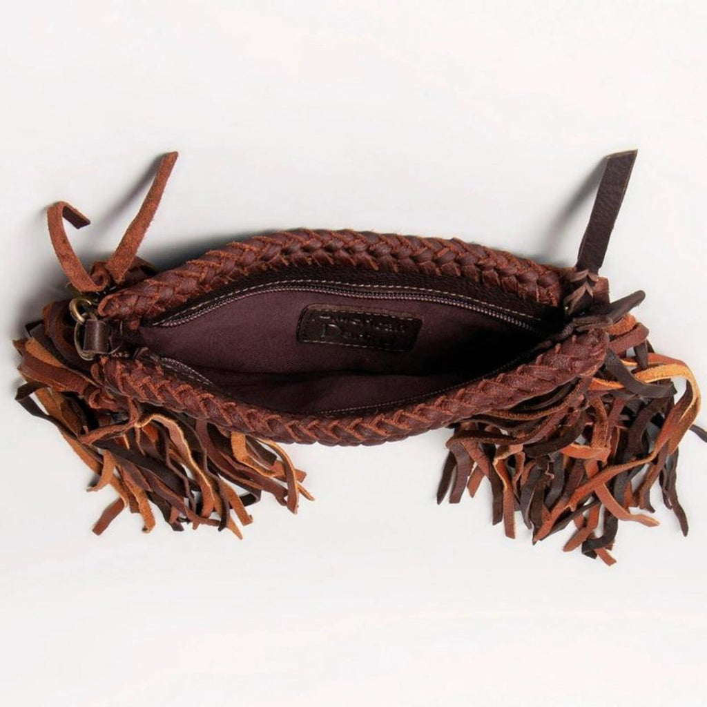 The interior of a dark brown western-style leather clutch featuring braided details and the "American Darling" brand logo stitched inside.