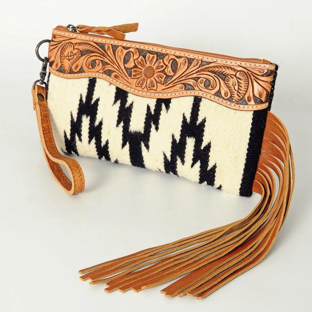 Frontier Fringe Leather Wristlet with hand-tooled leather detailing, black and white woven pattern, and long leather fringe.