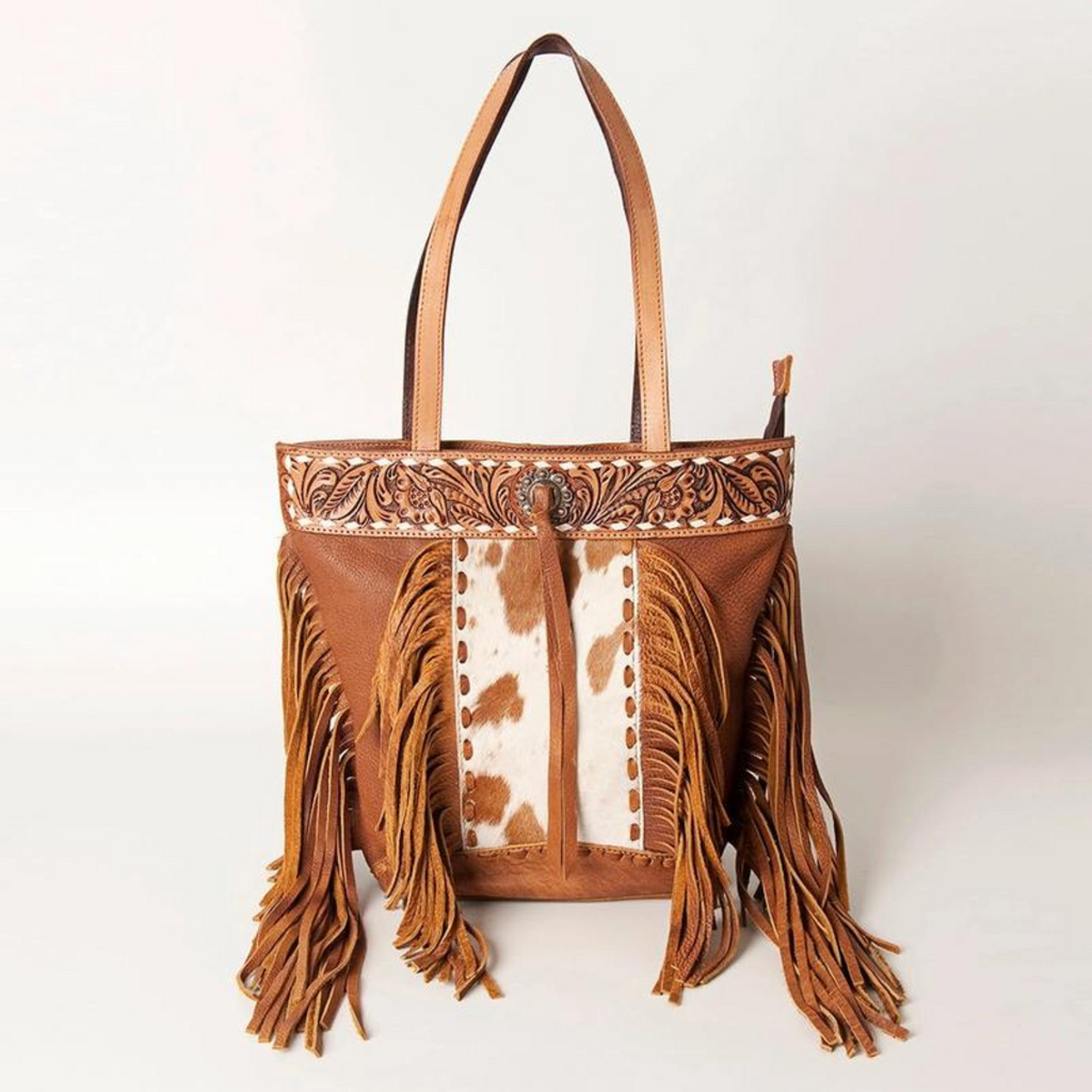 Hair-on cowhide leather tote with hand-tooled detailing and fringes by American Darling