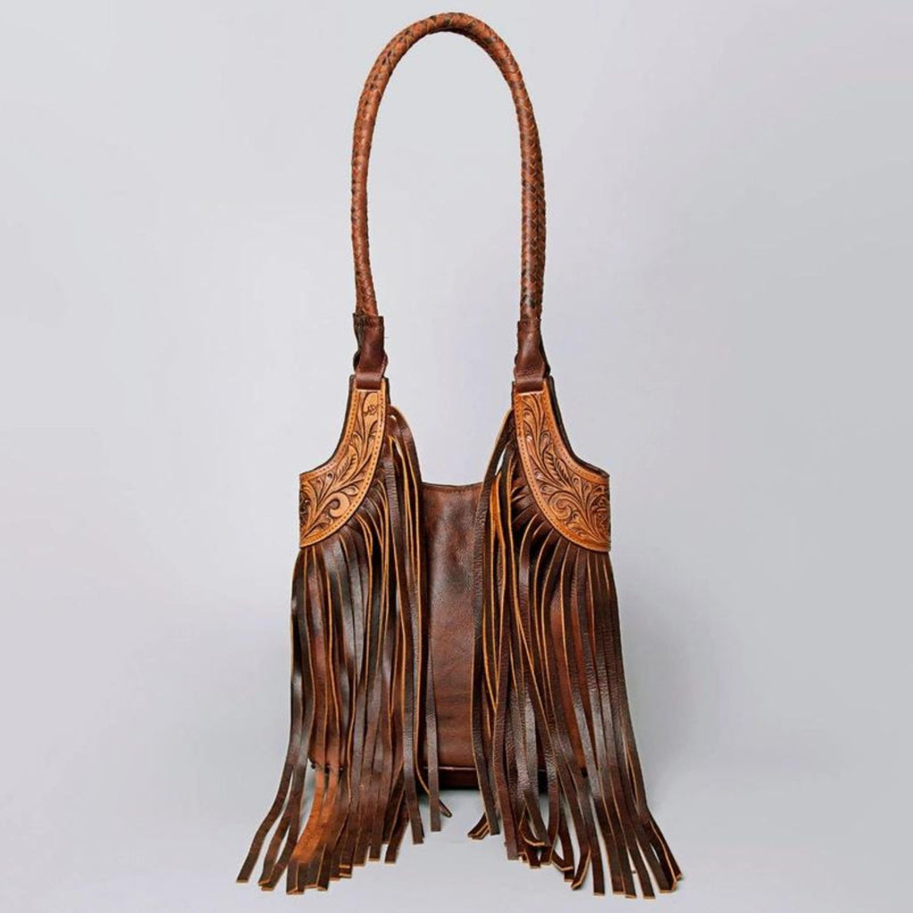 Hand-tooled leather fringe Western tote bag with intricate detailing and braided shoulder strap.