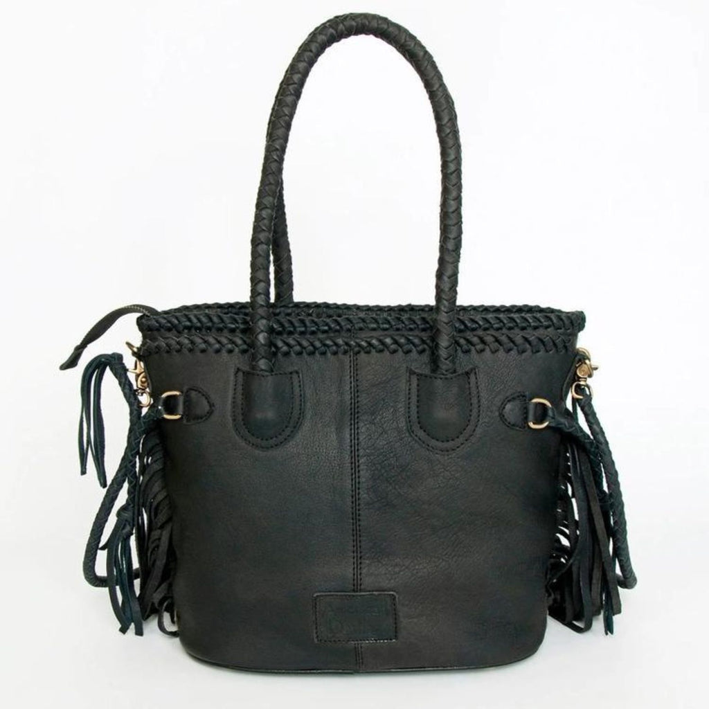 The back view of a black hair-on leather tote featuring braided leather handles and fringes, designed by American Darling.