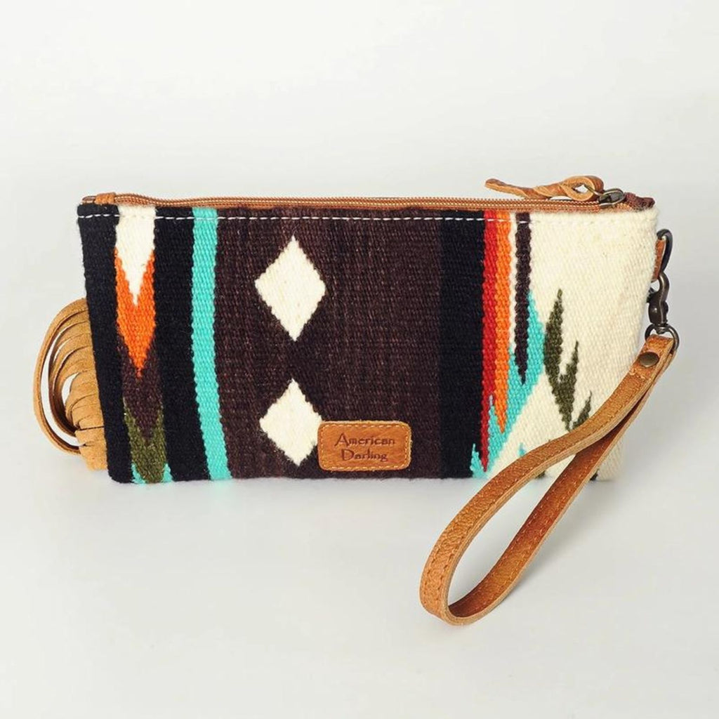 Back view of the Mustang Mesa Handwoven Wristlet featuring a brown wool base with colorful geometric diamond and stripe patterns, leather wrist strap, and visible American Darling logo patch.