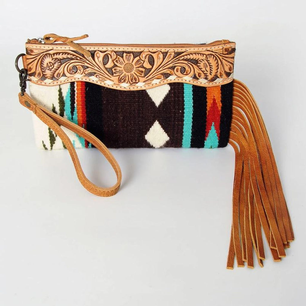 Front view of the Mustang Mesa Handwoven Wristlet showcasing intricate hand-tooled leather details, a brown wool base with colorful geometric patterns, and long tan leather fringe.