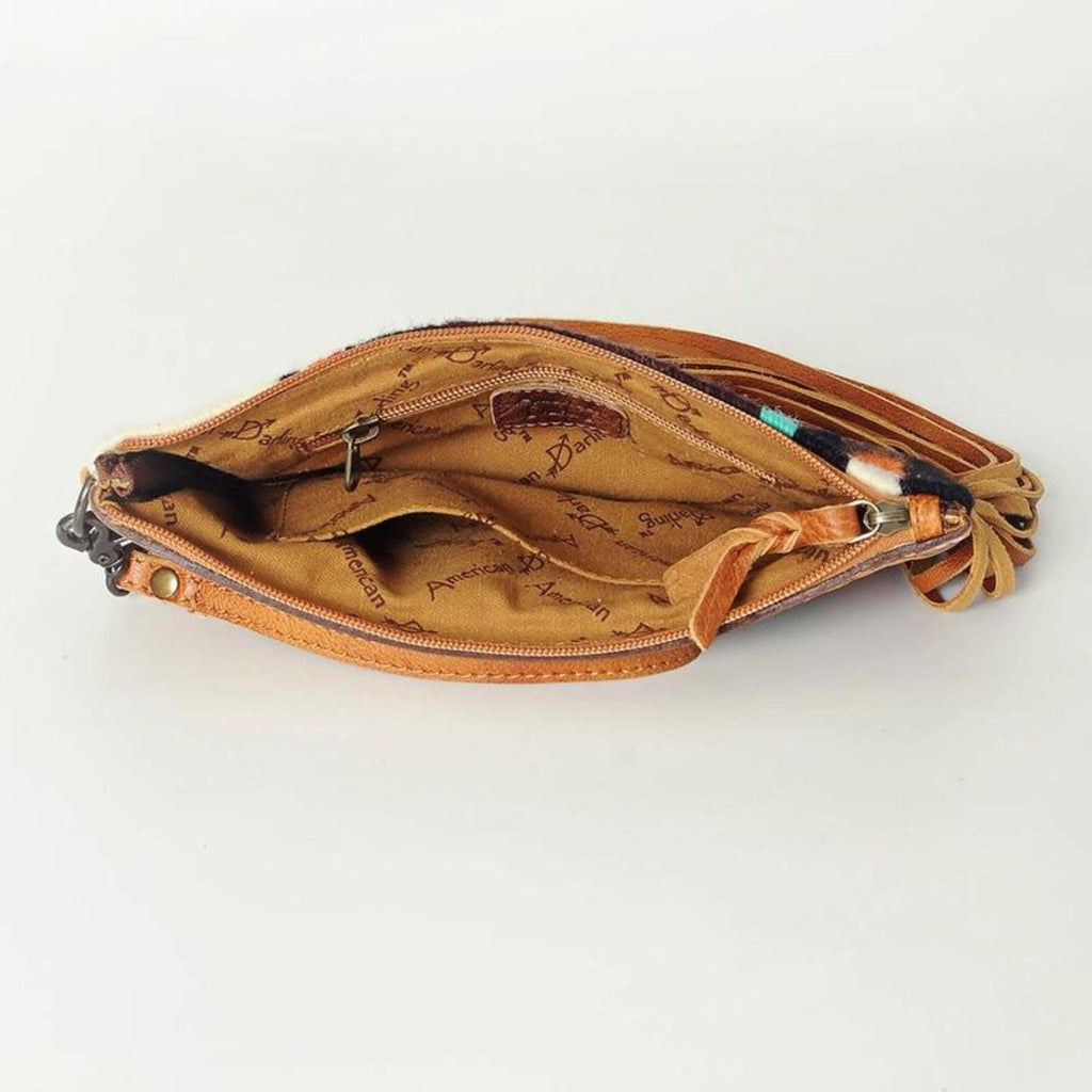 Interior view of the Mustang Mesa Handwoven Wristlet showcasing its spacious compartment with zippered pocket, fabric lining imprinted with 'American Darling' logo, and brown leather details.