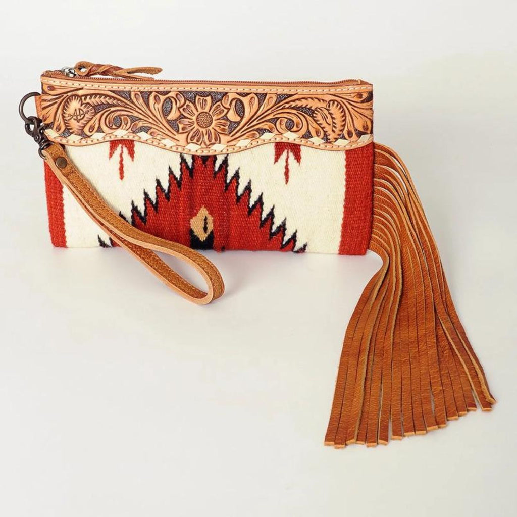 Front view of the Prairie Rose Leather Wristlet with detailed floral tooled leather trim, bold red and white southwestern woven fabric, and extended leather fringe.