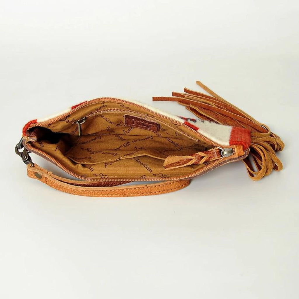 Interior view of the Prairie Rose Leather Wristlet showing the spacious compartment with branded fabric lining, zipper pocket, and leather tassel zipper pull.