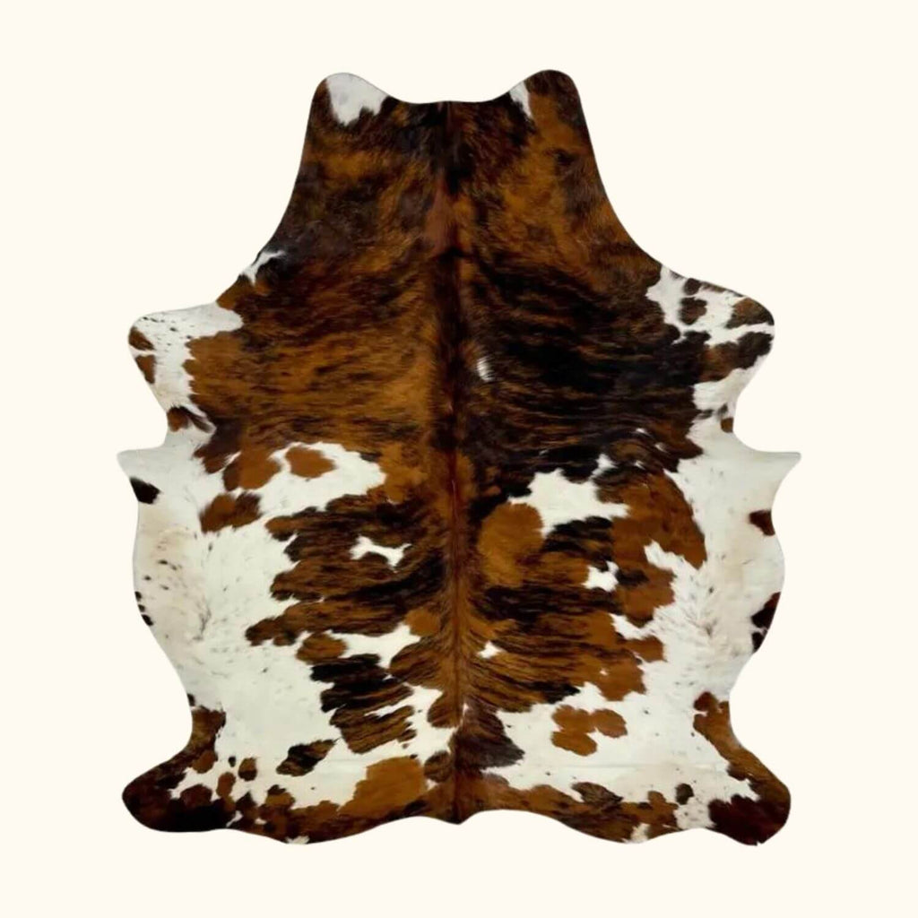 Product photo of a cowhide rug. Bring rustic charm to your space with our premium Brazilian cowhide rug.