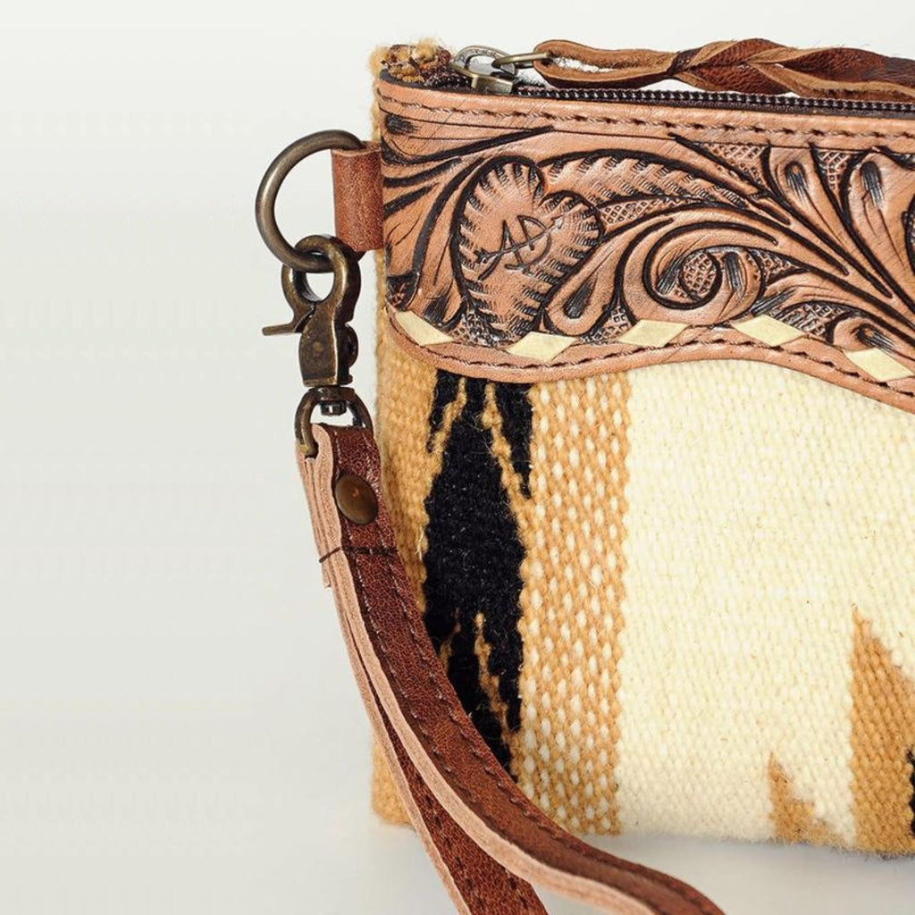 Close-up detail of the Saddle Blanket Sunset Wristlet showcasing the hand-tooled leather and antique hardware.