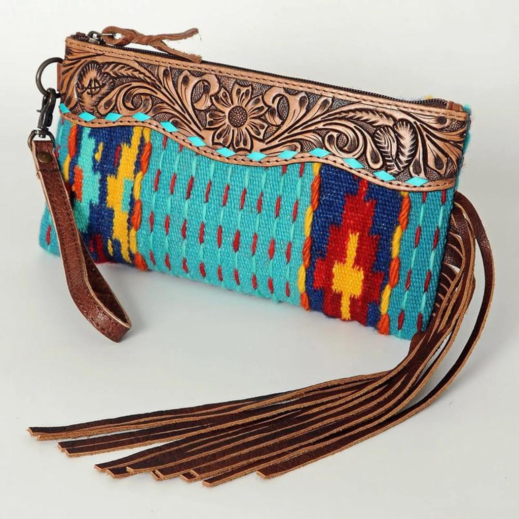 Sierra Sky Leather Fringe Bag with vibrant handwoven turquoise, red, and yellow pattern, detailed floral leather trim, and brown leather fringe accents.