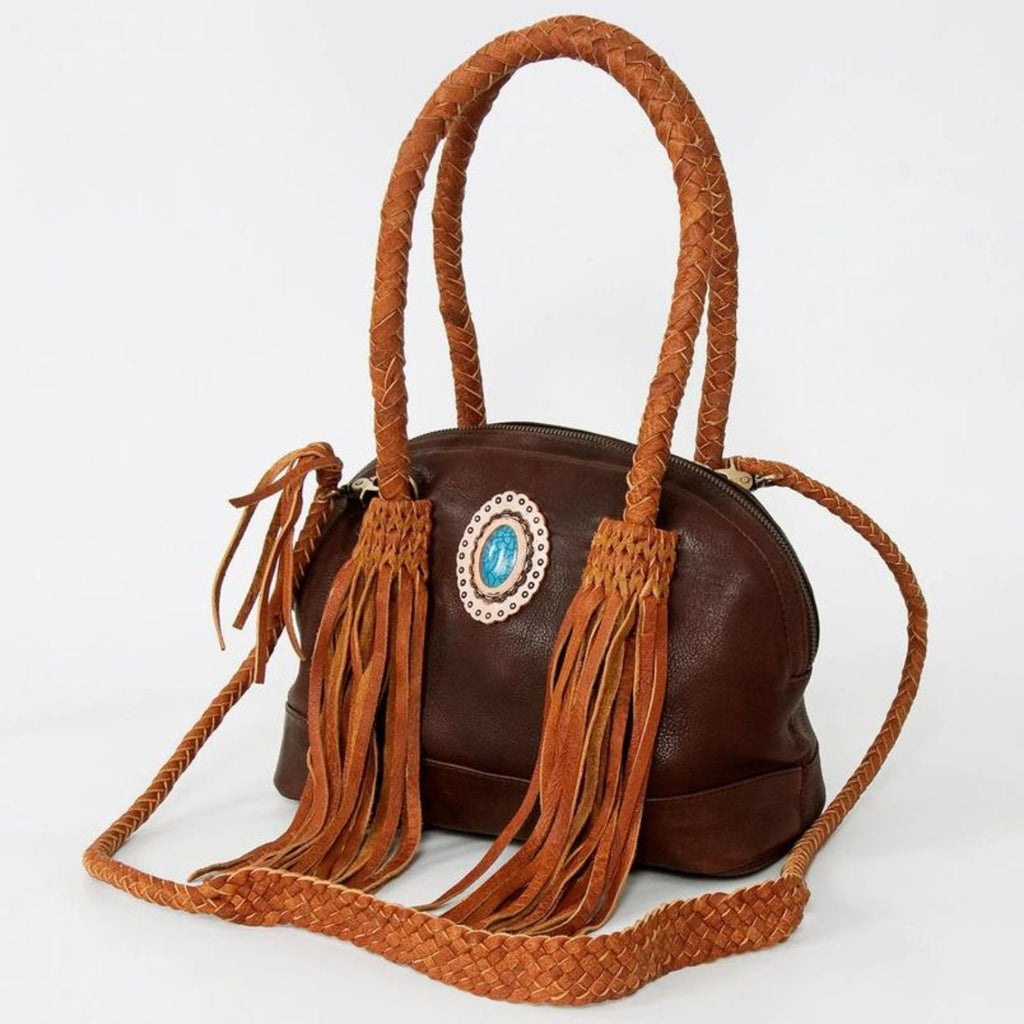 Side view of the Turquoise Trail Fringed Leather Tote featuring braided leather handles, fringe detailing, and a turquoise stone centerpiece in a handcrafted Western design.