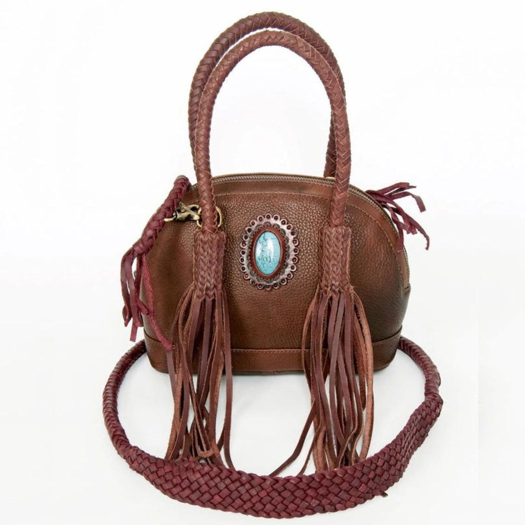 A variant of the Turquoise Trail Fringed Leather Tote, featuring braided handles, leather fringe, and a turquoise stone embellishment in a different shade of genuine leather for a unique Western-inspired look.