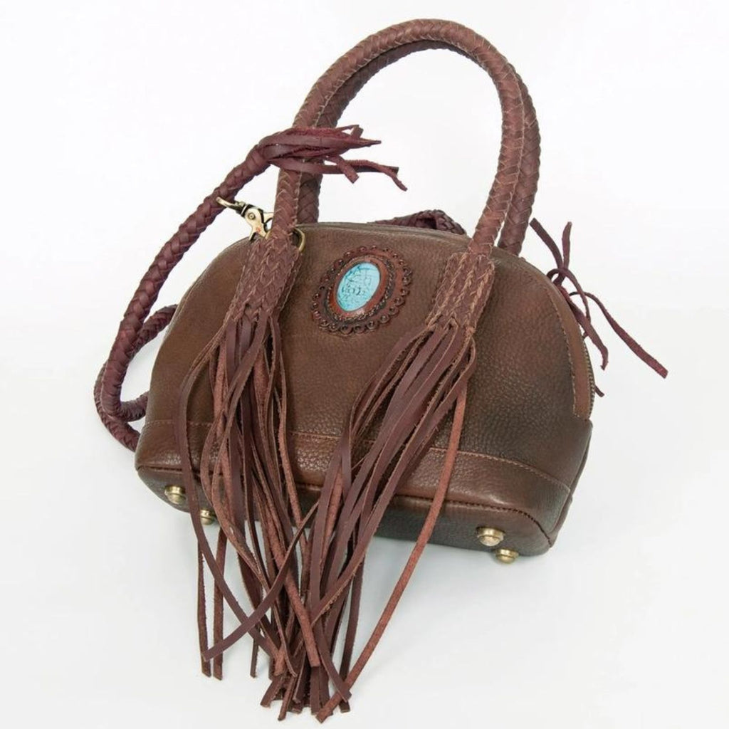 Side view of a variant of the Turquoise Trail Fringed Leather Tote, featuring braided handles, leather fringe, and a turquoise stone embellishment in a unique leather finish for a stylish Western look.