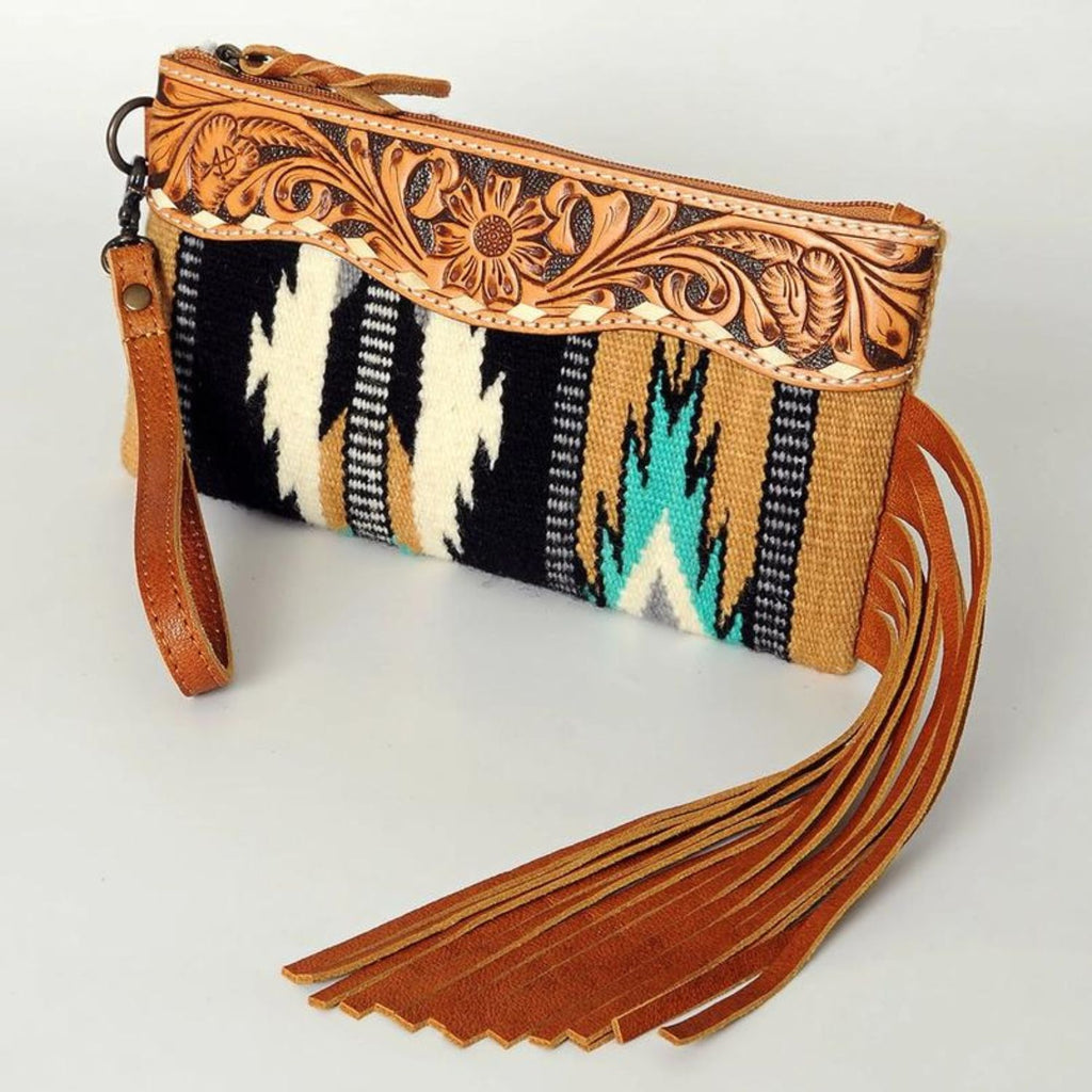 Western Trails Leather Fringe Wristlet featuring hand-tooled leather detailing, black and turquoise woven design, and long leather fringe.